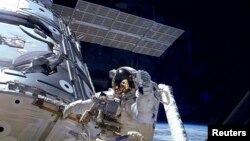 美宇航员在国际空间站外面行走的资料照片。
