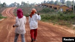 រូប​ឯកសារ៖ ស្ត្រី​ពីរ​នាក់​ដើរ​កាត់​ផ្ទះ​ក្នុង​ឧទ្យានជាតិ​បុទុមសាគរ​ខេត្ត​កោះកុង ដែល​ត្រូវ​បាន​សាងសង់​សម្រាប់​អ្នក​ដែល​ត្រូវ​បាន​​ជម្លៀសចេញ​ពី​ដី​ដែល​ត្រូវ​បាន​លក់។ រូប​ថតថ្ងៃ​ទី​២០ ខែ​កុម្ភៈ ឆ្នាំ​២០១២។ 