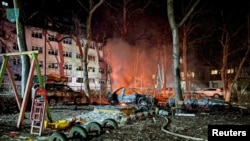 Mobil yang hancur terlihat di samping bangunan tempat tinggal yang rusak akibat serangan drone Rusia di Odesa, Ukraina, 17 Januari 2024. (Foto: via Reuters)