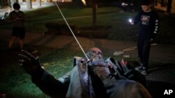 Orang-orang merekam patung Albert Pike yang dirobohkan dan dibakar oleh pedemo anti-rasisme di Washington D.C., 20 Juni 2020. Patung itu adalah satu-satunya patung jenderal Konfederasi yang ada di ibu kota AS.