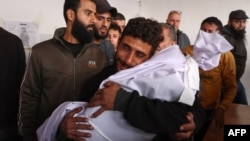 Seorang pria di Rumah Sakit Arab Al-Ahli menangis sambil menggendong jenazah anak berusia dua tahun yang tewas dalam serangan Israel di Kota Gaza, pada 5 Desember 2024. (Foto