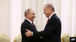 Presiden Turki Recep Tayyip Erdogan kanan, berjabat tangan dengan Presiden Rusia Vladimir Putin, di Teheran, Iran, Jumat, sebelum pembicaraan mereka, bagian dari KTT Rusia-Iran-Turki untuk membahas Suriah, Jumat, 7 September 2018. (Foto: AP)
