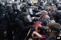 Capitol police officers in riot gear push back demonstrators trying to break a door of the U.S. Capitol on Jan. 6, 2021, in Washington. (Jose Luis Magana/AP)
