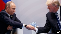 Presiden Rusia Vladimir Putin (kiri) berjabat tangan dengan Presiden Amerika Donald Trump saat menghadiri KTT G20 di Hamburg, 7 Juli 2017. (Foto: dok).