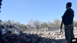 A police officer examines the damage at the site of Tuesday's suicide bombing, in Bannu, in northwestern Pakistan, March 5, 2025.