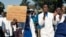 FILE - Doctors and medical staff march to Zimbabwe's Parliament, Sept. 19, 2019, in Harare demanding the safe return of Peter Magombeyi, whom protesters believe was taken because of his role organizing strikes to demand better pay and working conditions.