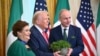 US President Donald Trump and Irish Prime Minister Micheal Martin (R) hold a bowl of shamrock alongside his wife Mary O'Shea (L) during a St. Patrick's Day Reception in the East Room of the White House in Washington, DC, on March 12, 2025. (Photo by Mande