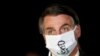 Presiden Brasil Jair Bolsonaro berbicara dengan wartawan sambil mengenakan masker pelindung saat tiba di Istana Alvorada, di tengah wabah penyakit virus korona, di Brasilia, 22 Mei 2020. (Foto: Reuters)