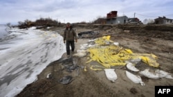 Harold Ilmar, yang bertanggung jawab menghentikan erosi lapisan tanah beku atau permafrost, berjalan di kawasan yang terdampak di desa Yupik Eskimo, Yukon Delta, Alaska, 19 April 2019. (Foto: AFP)