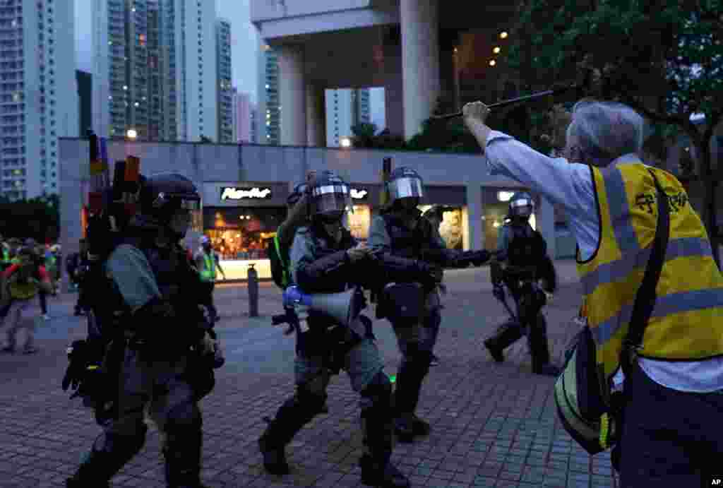 抗议者围堵机场外公路。港铁关闭所有进出机场的线路。在东涌站外，一位老者试图拦阻要逮捕抗议者的警察。(2019年9月1日)