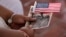 A woman holds a US flag before she became US citizen during a special naturalization ceremony in honor of Citizenship Day and Constitution day Ellis Island in New York on September 16, 2016.