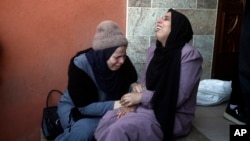 Članovi porodica poginulih Palestinaca ispred mrtvačnice u Kan Junisu (Foto: AP/Mohammed Dahman)