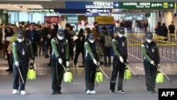 韩国仁川国际机场的工人为防范新型冠状病毒入侵在海关处喷洒消毒药水。（2020年1月21日）