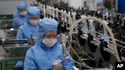 FILE - Workers of the Ryongaksan Soap Factory make disinfectant in Pyongyang, North Korea, March 19, 2020.