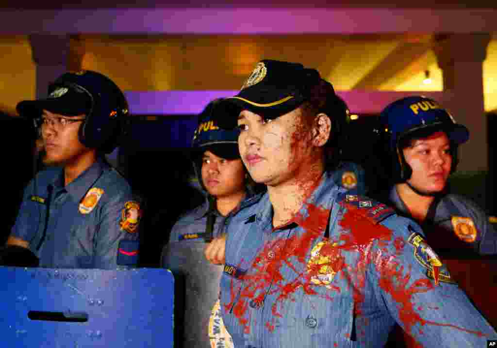 A police officer has her face and uniform splattered with red paint thrown by protesters during a rally at the U.S. Embassy in Manila to protest the recent Philippine Supreme Court&#39;s decision upholding the constitutionality of the Enhanced Defense Agreement or EDCA in the Philippines. The highest court&#39;s ruling effectively allows American forces, ships and planes to temporarily station in local military camps.&nbsp;