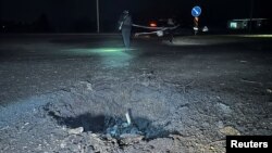 មន្ត្រីមានសមត្ថកិច្ចត្រួតពិនិត្យទីតាំង​ដែលត្រូវបានវាយប្រហារដោយ​ដ្រូនរបស់រុស្ស៊ី នៅតំបន់ Kharkiv ប្រទេសអ៊ុយក្រែន កាលពីថ្ងៃទី២៦ ខែមីនា ឆ្នាំ២០២៤។ 