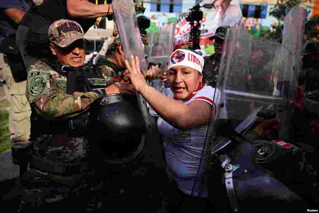 A demonstrator clashes with law enforcement officers as supporters of Peru's former President Pedro Castillo protest outside the penitentiary center where he is held, on the day of the beginning of his oral trial on charges of rebellion and other offenses against the state, in Lima.