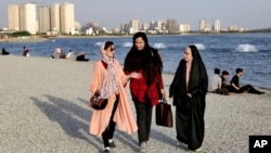2019年7月6德黑兰波斯湾烈士湖岸边行走的伊朗妇女。