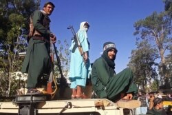 Pejuang Taliban berdiri di atas kendaraan di sepanjang pinggir jalan di Herat, kota terbesar ketiga di Afghanistan. (Foto: AFP)