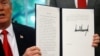 U.S. President Donald Trump displays an executive order on immigration policy after signing it in the Oval Office at the White House in Washington, June 20, 2018.