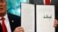 U.S. President Donald Trump displays an executive order on immigration policy after signing it in the Oval Office at the White House in Washington, June 20, 2018.