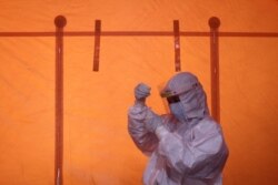 Seorang petugas kesehatan memegang sampel usap untuk tes antigen COVID-19, 3 Januari 2021. (Foto: Hendra Nurdiyansyah/Antara via REUTERS)