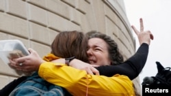 Terminated U.S. Agency for International Development (USAID) employee Caitlin Harwood hugs her cousin Samantha Kent after laid-off USAID workers cleared out their desks and collected personal belongings, during a sendoff in Washington.