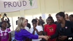 FILE - Then Secretary of State Hillary Rodham Clinton shakes hands at Camp GLOW (Girls Leading Our World) run by the Peace Corps, in Lilongwe, Malawi, Aug. 5, 2012.