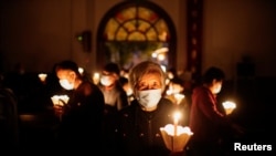 资料照片：新冠疫情期间，人们在上海的一座天主教堂参加复活节守夜礼。(2021年4月3日)