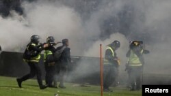 Polisi anti huru hara menembakkan gas air mata usai pertandingan sepak bola antara Arema FC vs Persebaya di Stadion Kanjuruhan, Malang (1/10) lalu. 