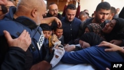 Istri Hamza al-Dahdouh (kanan), jurnalis jaringan televisi Al Jazeera, dan ayah Hamza, Wael al-Dahdouh kepala biro Al Jazeera di Gaza (kiri) berduka saat pemakaman Hamza, yang terbunuh dalam serangan udara Israel di Rafah, Jalur Gaza Senin, 7 Januari 2024.