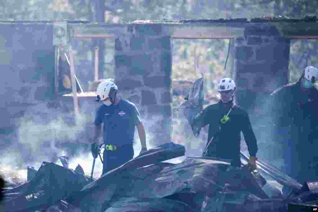 ក្រុមអ្នកពន្លត់អគ្គីភ័យកំពុងពិនិត្យមើលផ្ទះមួយខ្នងដែលត្រូវបានបំផ្លាញដោយភ្លើងឆេះព្រៃមួយកន្លែង នៅក្រុង Malden រដ្ឋ Washington កាលពីថ្ងៃទី ៨ ខែកញ្ញា ឆ្នាំ២០២០។