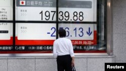 在东京商业区的一家证券行外面，有人看着日经指数（2017年8月9日）