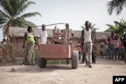 FILE - A Central African Republic family moves their belongings as they leave after four years in a refugee camp in Betou, northern Congo-Brazzaville, on March 30, 2018, as CAR refugees are taken back to the Central Africa Republic.