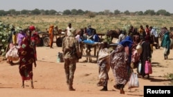 Keluarga-keluarga menyelamatkan diri dari Ardamata di Darfur Barat menuju Adre di Chad, setelah gelombang kekerasan antaretnik meningkat, 7 November 2023. (Foto: El Tayeb Siddig/Reuters)