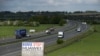 FILE - A sign reading "Boris Stop Huawei" is seen next to the M40 motorway, Tetsworth, Britain, May 1, 2020.