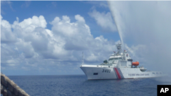 资料照片:一艘中国海警船驶近在南中国海斯卡伯勒礁(黄岩岛)附近捕鱼的菲律宾渔船 (美联社2015年9月23日)