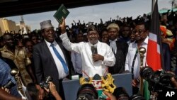 Opposition leader Raila Odinga holds up a bible during a "swearing-in" ceremony at Uhuru Park in downtown Nairobi, Kenya, Jan. 30, 2018.