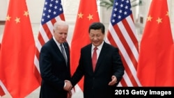 资料照片：,中国国家主席习近平在北京人民大会堂与当时的美国副总统乔·拜登握手合影。(2013年12月4日)