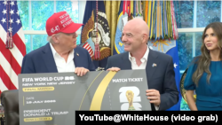 在宣布2026年世界杯足球赛的抽签仪式将于12月5日在华盛顿市的肯尼迪中心举行后，美国总统特朗普和国际足联主席因凡蒂诺在白宫展示一张世界杯门票。旁边为美国国土安全部长诺姆。(2022年8月22日)
