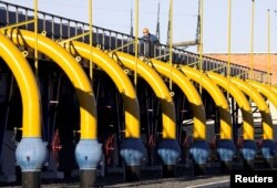 Seorang pekerja memeriksa pipa di stasiun kompresor gas di pipa Yamal-Eropa dekat Nesvizh, sekitar 130 km barat daya Minsk, 29 Desember 2006. (Foto: REUTERS/Vasily Fedosenko)