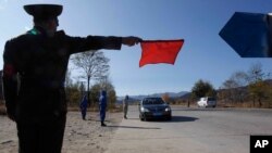 지난해 10월 북한 원산에서 신종 코로나바이러스 방역 요원들이 진입하는 차량을 통제하고 있다. (자료사진)