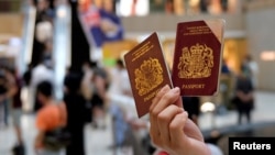 一名香港示威者在反对港版国安法的抗议中手举英国国民海外护照。（2020年6月1日）