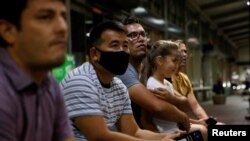 Arhiva - Stariji brat Sajeda Abdula Vase Mahidija drži svoju sestru dok čeka mlađeg brata da stigne u For Li, Vašington, u Sakramentu, Kalifornija, 5. avgusta 2021. Mahidi je prevodilac koji je radio za SAD i ranije je stigao u Ameriku.