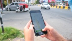 ស្ត្រីម្នាក់ប្រើទូរស័ព្ទស្មាតហ្វូនដើម្បីប្រើសេវាធ្វើដំណើរ PassApp នៅរាជធានីភ្នំពេញ កាលពីថ្ងៃទី២ ខែមីនា ឆ្នាំ២០២១។ (ទុំ ម្លិះ/វីអូអេ)