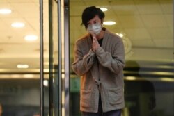 香港民主活动人士、歌手何韵诗获保释后走出警察局时向支持者鞠躬致谢。（2021年12月30日）