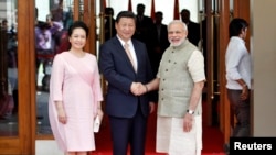 中国国家主席习近平访问印度，和印度总理纳伦德拉•莫迪（右）握手。站在左边的是习近平夫人彭丽媛（2014年9月17日）