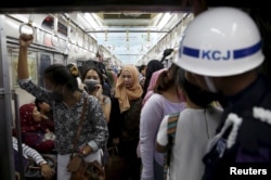 FILE - A security personnel stands guard inside a train carriage for women at Manggarai train station in Jakarta, Jan. 8, 2016.