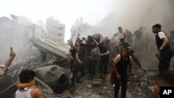 Sejumlah warga Palestina tampak mengevakuasi jenazah dari reruntuhan bangunan setelah serangan udara Israel menyerang kamp pengungsi Jebaliya, Jalur Gaza, pada 9 Oktober 2023. (Foto: AP/Ramez Mahmoud)