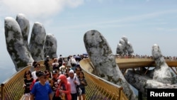 Tourists walk along Gold Bridge on Ba Na hill near Danang city, Vietnam, Aug. 1, 2018. 